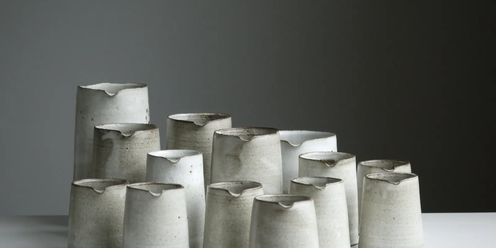 Stoneware cups stacked on a dark table